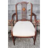 An Edwardian open arm easy chair with pink striped seat, three plain central splats and two similar