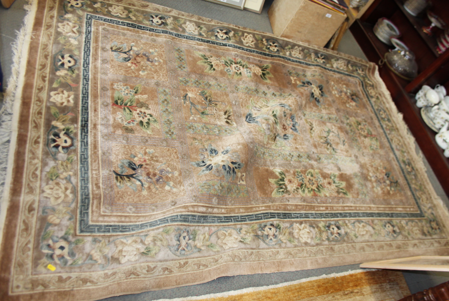 A Chinese silk carpet decorated thirteen floral panels on a beige ground and main floral border