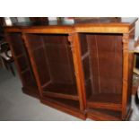 A late 19th century walnut breakfront open bookcase with fluted pilasters and adjustable shelves,