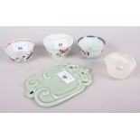 Three Chinese porcelain tea bowls, a turned hardstone tea bowl and a celadon glazed wall plaque,