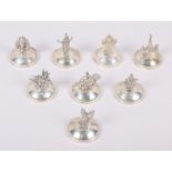 A set of eight Thai sterling silver place card holders, decorated figures, etc