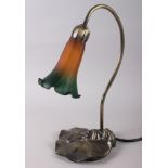A Tiffany design table lamp with orange and green coloured glass shade, on a metal base formal as