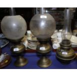 Three brass oil lamps, one shade and two chimneys
