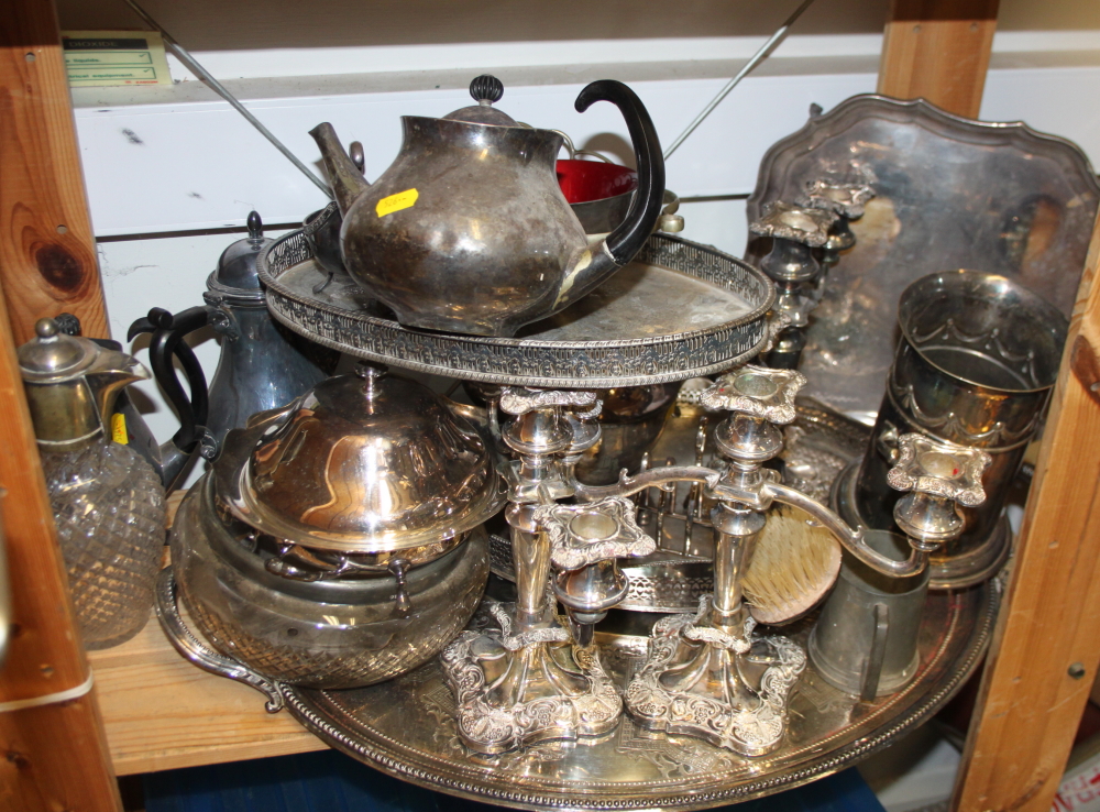A silver plated two handled tray, three candelabra, an Eric Clement teapot and coffee pot, a toast
