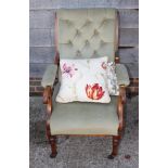 A late 19th century polished as walnut scroll arm chair, upholstered in a sage green fabric, on