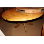 A pine circular dining table, on turned pedestal and quadruple splay supports, 60" dia