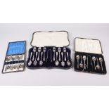 A cased set of six silver apostle teaspoons with matching tongs and two other silver plated sets