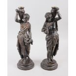 A pair of spelter figure candlesticks, Middle Eastern/Nubian figures carrying oil jars, 14 1/2" high