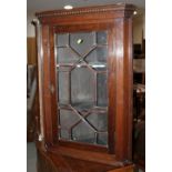 An oak corner cupboard with astragal glazed door enclosed shelves, 27" wide