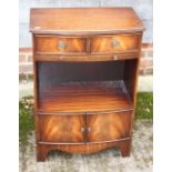 A mahogany bowfront bedside cabinet, fitted two drawers over slide, central recess and cupboards, on