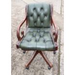 A mahogany desk elbow chair, upholstered in a green leather