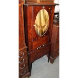 A mahogany cupboard with organ pipe panel door over cupboard, standing on square tapering supports