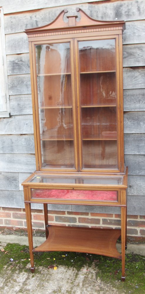 A Sheraton revival mahogany and banded inlaid display cabinet with swan neck pediment over glazed