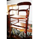 A beech framed elbow chair with cane seat, on turned and stretchered supports