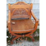 A carved oak Glastonbury chair with 'X' frame supports