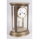 An oval brass cased four glass mantel clock with white enamel dial and Roman numerals