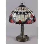 An Art Nouveau design table lamp with leaded glass shade, 14" high