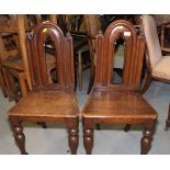 A pair of mid 19th century Gothic design oak hall chairs, on turned supports