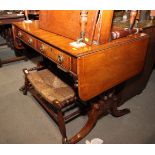 A George IV mahogany and banded sofa table, fitted two drawers, on brass line inlaid lyre end