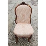 An oak framed Victorian nursing chair, upholstered in a patterned pink fabric, and a similar loop