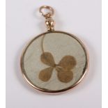 A 9ct gold locket inset two four-leaf clovers