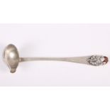 A Danish white metal sauce ladle with all-over planished decoration and amber cabochon to the finial