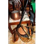A brass helmet coal scuttle, a copper warming pan, a copper saucepan and lid, a brass bell and an