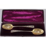 A pair of Georgian silver bottom marked serving spoons with later pierced, engraved and embossed