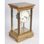 A brass cased four glass mantel clock with white enamel dial and Arabic numerals, on stepped base,