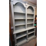 A duck egg blue painted open bookcase, the upper section fitted two arch top compartments over two