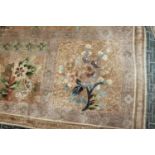A Chinese silk carpet decorated thirteen floral panels on a beige ground and main floral border