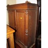 An oak wall cupboard enclosed two doors flanked turned columns, 23 1/2" wide