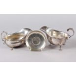 A silver sauce boat with scrolled handle, another similar and a pin dish inset with Churchill crown,