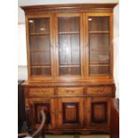 An oak bookcase with three glazed doors enclosed three shelves over three drawers and three