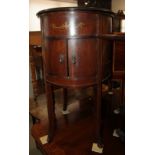 An early 20th century polished as walnut and painted oval record player cabinet, fitted two doors,