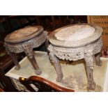 A pair of Chinese hardwood stands with marble tops and pierced and floral carved decoration, on