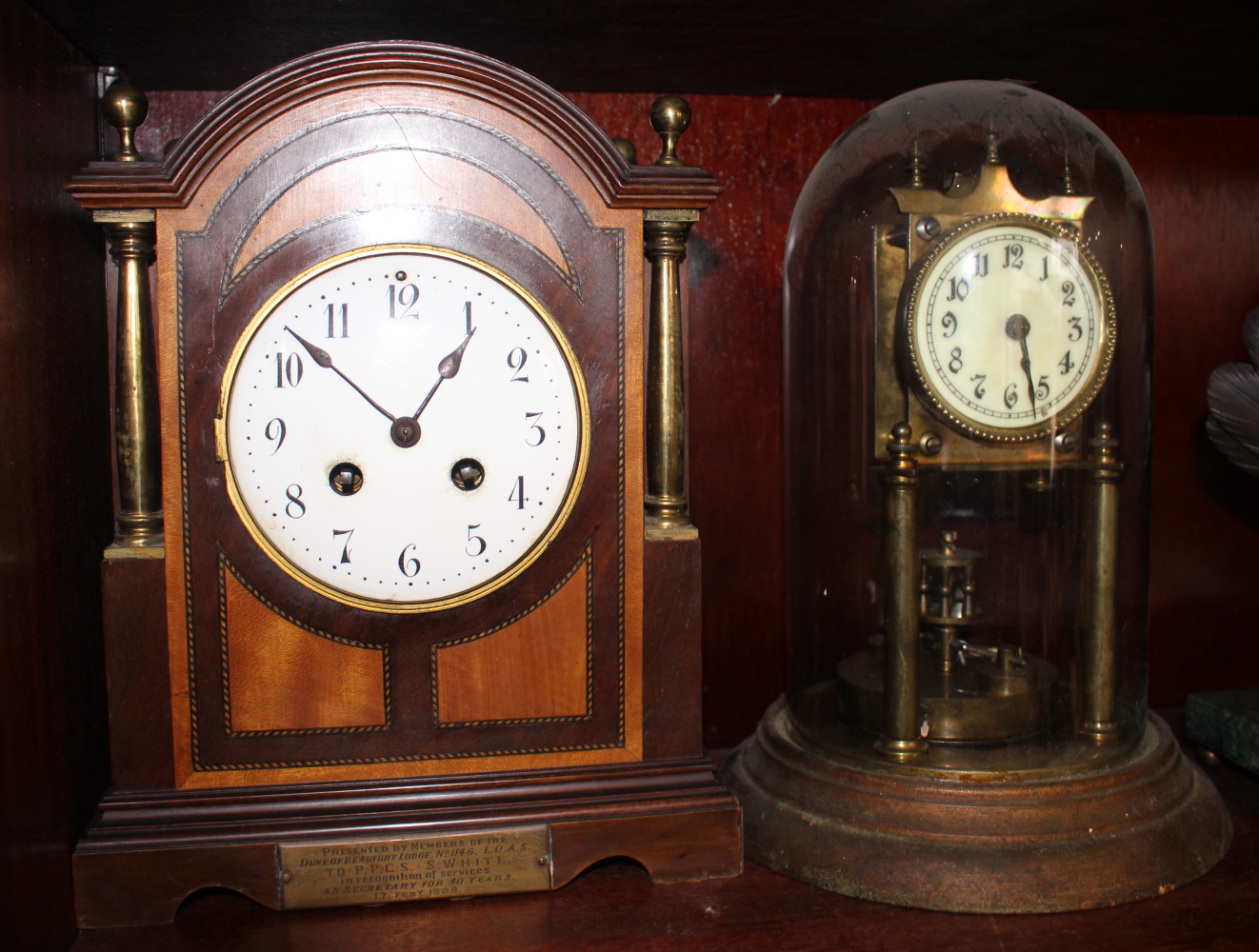 An anniversary clock with enamel dial and Arabic numerals, 11" high, and an Edwardian mahogany and