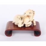 A Japanese carved ivory netsuke, formed as a recumbent goat and rabbit, signature to underside, 1
