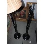 A pair of ebonised standard lamps with turned columns, on circular bases