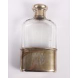 A cut glass spirit flask with silver removable cup and silver lid