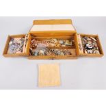 A tan coloured jewellery box containing a selection of costume jewellery, including a Continental
