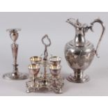 A Victorian silver plated egg cup stand with four cups and spoons, an oval plated candlestick, a