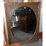 An oval wall mirror, in rectangular gilt frame, 39" x 50" overall