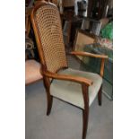 A 1930s fireside chair with caned panel back and stuffed over seat