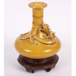 A 19th century Chinese yellow glazed pottery squat baluster vase, decorated with a sinuous dragon in