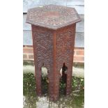 An early 20th century floral carved hardwood hexagonal top occasional table, on panel end