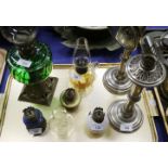 Two early 20th century adjustable student's lamps, a green glass oil lamp, four miniature oil lamps,
