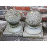 A pair of cast stone garden finials, on square bases, 12" high