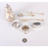 A silver sugar caster, three silver napkin rings, a silver fork, two silver teaspoons and a white