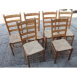 A set of six beech ladder back dining chairs with rush envelope seats, on turned and stretchered